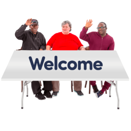 Three people at a table saying welcome